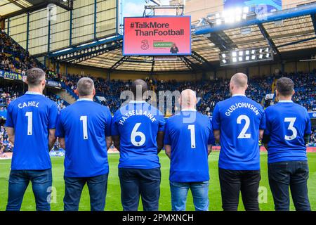 USO EDITORIALE SOLO ex giocatori di Chelsea Gary Cahill, Jimmy Floyd Hasselbaink e Eiður Guðjohnsen (camicie denominate) e fan di Chelsea (l-r) Marcus Cuthbert, Carlo capelli, E Fabio Agostini mostra il numero di assistenza di 24 ore dei Samaritani 116 123 stampato sul retro delle loro camicie durante il lancio della campagna TalkMoreThanFootball da tre, sponsor dei Samaritani, durante l'intervallo di tempo tra Chelsea e Brighton a Stamford Bridge, Londra. Data immagine: Sabato 15 aprile, 2023. Foto Stock