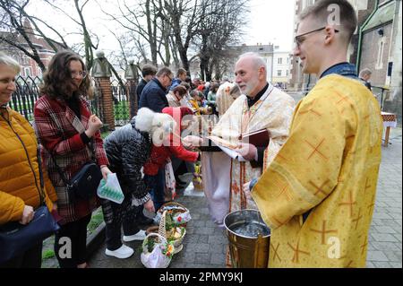 Lviv, Ucraina 15 aprile 2023. Un sacerdote ucraino benedice i credenti nella Chiesa dei SS. Olha ed Elisabetta, chiesa cattolica che celebrano la Pasqua per segnare la risurrezione di Gesù Cristo dai morti e la fondazione della fede cristiana. Foto Stock