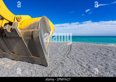 Borghetto Santo Spirito, Italia - aprile 01 2023: Escavatore funzionante e spiaggino in mare Foto Stock