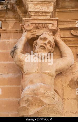 Mdina, Malta - 13 novembre 2022: Particolare della facciata del Museo della Cattedrale di San Paolo, un atlantico, figure maschili come lesene, statua di pietra calcarea che regge Foto Stock