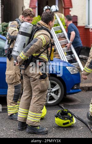 Servizio antincendio e di soccorso della contea di Essex che risponde a un incendio di una casa a Westcliff on Sea, Essex, Regno Unito. Vigili del fuoco che indossano un apparecchio di respirazione Foto Stock