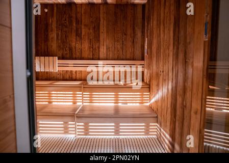Interno della sauna con parete in legno e panca in un hotel moderno Foto Stock