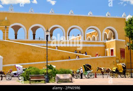 Una veduta del monastero e delle carrozze trainate da cavalli nel 'pueblo magico' di Izamal, Yucatan, Messico. Foto Stock