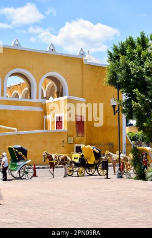 Le colorate carrozze trainate da cavalli per i turisti nella storica città gialla di Izamal, Yucatan, Messico. Foto Stock