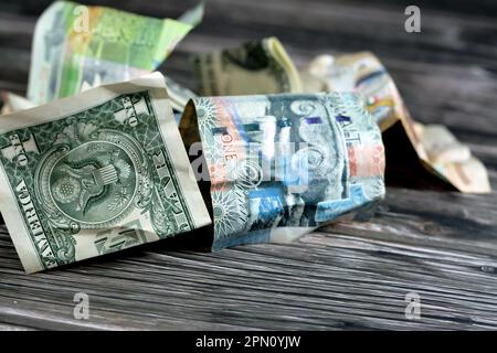 Corrugato e sbriciolato Kuwaiti mezzo, quarto e un dollaro KWD banconote dinar e 1 dollari americani denaro contante, inflazione di denaro e perdita di valore, d Foto Stock