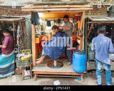 L'uomo si taglia i capelli in un piccolo barbiere a Dhaka, la capitale del Bangladesh. Foto Stock