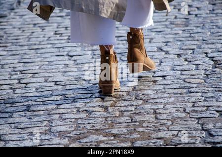 piedi di una donna che cammina negli stivali Foto Stock