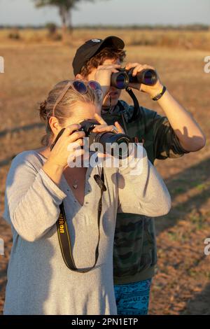 Turisti che osservano e fotografano la fauna selvatica in Zambia Foto Stock