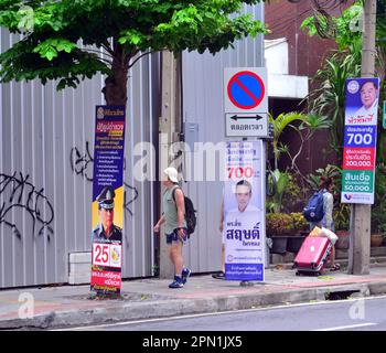 I candidati alle elezioni utilizzano i cartelli appesi ai mobili per la strada per pubblicizzare se stessi ai potenziali elettori del distretto di Silom, nel centro di Bangkok, in Thailandia, nel sud-est asiatico. Le elezioni generali si terranno in Thailandia il 14th maggio 2023, dopo lo scioglimento della 25th Camera dei rappresentanti il 20th marzo 2023. La gente cammina oltre i cartelli elettorali su Surawong Road, quartiere di Silom. Foto Stock