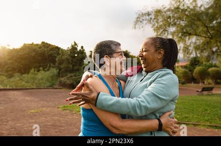 Donne anziane multirazziali felici che si divertono dopo le attività di allenamento in un parco pubblico - concetto di persone anziane sane Foto Stock