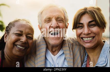 Felice gente multirazziale con età diversa che ha divertimento sorridente davanti alla macchina fotografica all'aperto Foto Stock