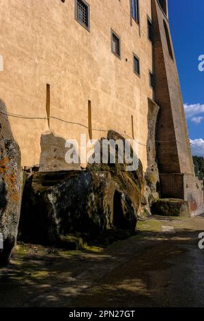 Fondamenta rocciose: Questo angolo del palazzo rinascimentale del 1500s costruito dalla potente famiglia Orsini a Bomarzo, Lazio, Italia, segue i contorni di enormi massi vulcanici sul suo sito collinare. Sotto il Palazzo, Vicino Orsini ha creato il bizzarro Parco dei Mostri, scultura grottesca manierista in un giardino terrazzato poi dedicato alla moglie Giulia Farnese. Foto Stock