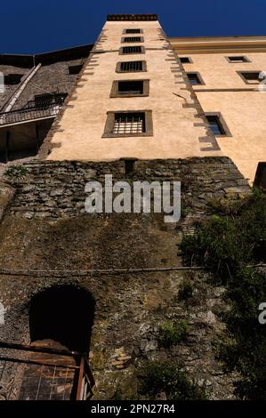 Prospettiva sulla vita sfarzosa: Le finestre sbarrate salgono la torre delle scale fino alle mura restaurate di Palazzo Orsini a Bomarzo, Lazio, Italia, trasformate in grandioso palazzo rinascimentale dall'ex soldato della fortuna, Duca Vicino Orsini. Sotto di essa, crea la Villa a terrazze delle meraviglie, piena di bizzarre opere manieriste e oggi conosciuta come Parco dei Mostri. Foto Stock