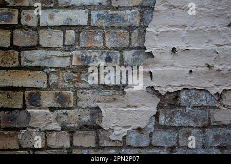 Vecchio muro in mattoni con vista ravvicinata del cappotto di scagliatura Foto Stock