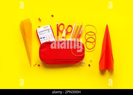 Composizione con forniture di cancelleria e piani di carta su sfondo giallo Foto Stock