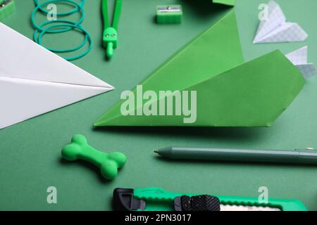 Composizione con forniture di cancelleria e piani di carta su sfondo verde Foto Stock