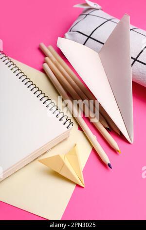 Composizione con forniture di cancelleria e piani di carta su sfondo rosa Foto Stock