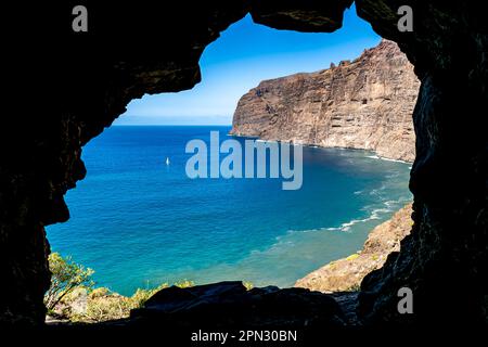 Ammira le acque della baia di Los Gigantes dall'ingresso di una piccola grotta, con le imponenti scogliere di Acantilados de Los Gigantes che torreggiano sul mare. Foto Stock