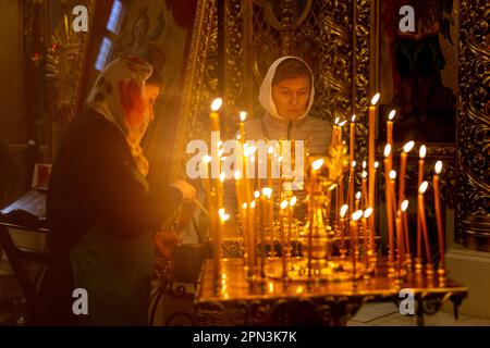 I credenti ucraini bruciano candele durante le celebrazioni del Sabato Santo in San Il Monastero di Michele con la cupola dorata nel centro di Kyiv, la capitale dell'Ucraina, il 16 aprile 2023. Secondo la tradizione i fedeli portano il loro cibo pasquale in un cestino da purificare, è sempre Pasha (pane pasquale), uovo dipinto (pysanka) tra l'altro. La maggior parte degli ucraini sono cristiani ortodossi o cattolici greci, entrambi osservano il rito orientale della Pasqua. Kyiv rimane relativamente pacifica mentre l'invasione russa continua e l'Ucraina si prepara ad una controffensiva primaverile per riprendere la terra Ucraina occupata Foto Stock