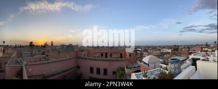 Marocco: Tramonto da un alto tetto, skyline di Marrakech, una delle città imperiali del Marocco situata a ovest delle colline pedemontane dell'Atlante Foto Stock