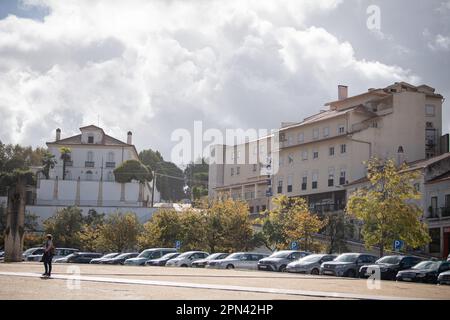 Un'area urbana trafficata con edifici e auto parcheggiate ad Alcobaca, Portogallo Foto Stock