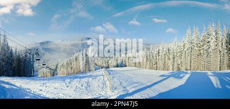 Paesaggio montano invernale con skilift e pista da sci. Stazione sciistica di Bukovel, Ucraina. Foto Stock