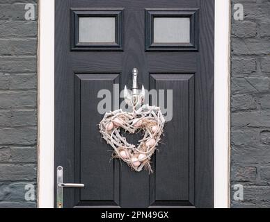 Corona decorativa con uova di Pasqua appese sulla porta, Edinbugh, Scozia, Regno Unito Foto Stock