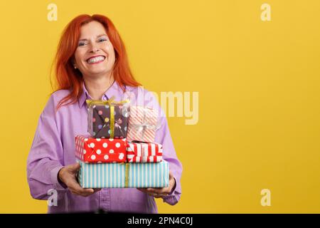 Felice donna matura arrheaded che riceve i regali per il giorno della madre Foto Stock