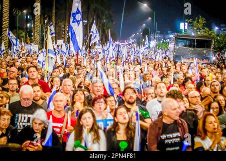 I manifestanti israeliani detengono bandiere durante una manifestazione anti-riforma a Netanya, a nord di Tel Aviv, sabato 15 2023 aprile. Centinaia di migliaia di persone si sono radunate per la settimana diritta del sabato 15th contro i piani di revisione giudiziaria della coalizione di Netanyahu, un giorno dopo che l'agenzia di rating Moody's ha declassato le prospettive economiche di Israele da positive a stabili in mezzo alle proposte altamente controverse della coalizione di assestare la magistratura. Foto di Eyal Warshavsky centinaia di migliaia di persone si sono radunate per la settimana diritta 15th sabato contro i piani di revisione giudiziaria della coalizione di Netanyahu, un giorno dopo Foto Stock