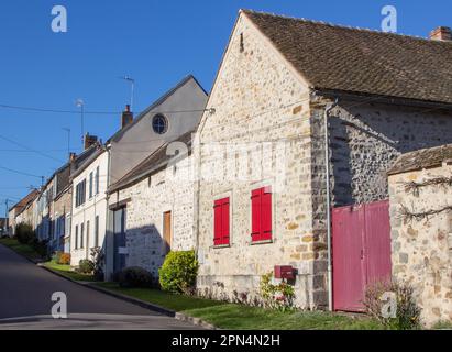 Flagy: I proprietari di questa casa in pietra con chiuse rosse seguono la tendenza locale, trasformando il pavimento in un giardino anteriore, insolito per la Francia Foto Stock