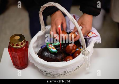 Una donna ortodossa mette le uova di Pasqua in un cesto dove saranno benedette dal sacerdote Igor Tatarintsev, in celebrazione della resurrezione di Cristo. Pasqua ortodossa celebrata in Francia, nella parrocchia ortodossa Madre di Dio e San Alessandro di Neva. I fedeli della Chiesa Ortodossa celebrano la risurrezione di Gesù Cristo, recandosi nella Chiesa per pregare i santi riti, portando cibo e bevande alla benedizione. E' l'atto più importante dei Riti Cristiani ortodossi. (Foto di Elsa A Bravo/SOPA Images/Sipa USA) Credit: Sipa USA/Alamy Live News Foto Stock