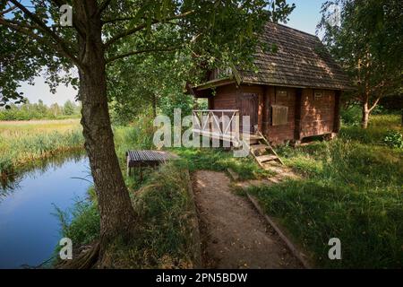 Bagno casa sulla riva del laghetto in estate. Foto Stock