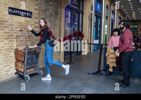 LONDRA, INGHILTERRA - 15 aprile 2023 Fan of Harry Potter ricrea spingendo un carrello verso la piattaforma nove e tre quarti dal film Foto Stock