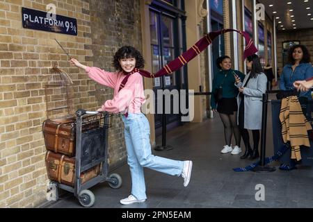 LONDRA, INGHILTERRA - 15 aprile 2023 Fan of Harry Potter ricrea spingendo un carrello verso la piattaforma nove e tre quarti dal film Foto Stock