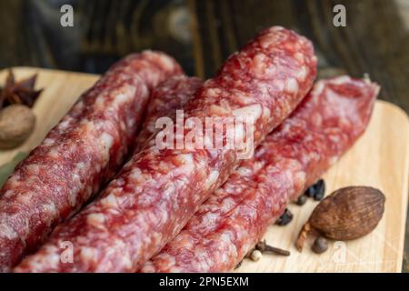 Salsiccia di vitello essiccata durante l'affettatura, preparazione di snack da salsiccia di vitello essiccata Foto Stock