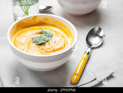 Zuppa di zucca con prezzemolo su fondo tovagliolo grigio Foto Stock