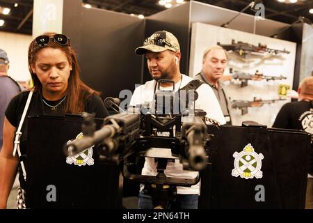 INDIANAPOLIS, INDIANA - APRILE 15: Gli ospiti guardano una mitragliatrice all'Ohio Ordnance Works Inc., stand durante le riunioni annuali e le mostre della National Rifle Association presso l'Indiana Convention Center il 15 Aprile 2023 ad Indianapolis, Indiana. Il convegno, che si prevede attirerà circa 70.000 ospiti, è stato aperto venerdì. (Foto di Jeremy Hogan/The Bloomingtonian) Foto Stock