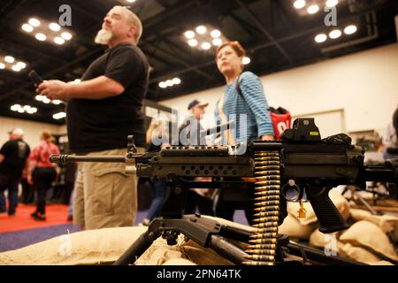 INDIANAPOLIS, INDIANA - APRILE 15: Gli ospiti guardano una mitragliatrice all'Ohio Ordnance Works Inc., stand durante le riunioni annuali e le mostre della National Rifle Association presso l'Indiana Convention Center il 15 Aprile 2023 ad Indianapolis, Indiana. Il convegno, che si prevede attirerà circa 70.000 ospiti, è stato aperto venerdì. (Foto di Jeremy Hogan/The Bloomingtonian) Foto Stock