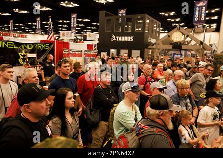 INDIANAPOLIS, INDIANA - Aprile 15: Gli ospiti si riuniscono allo stand Stag Arms per ottenere articoli gratuiti che vengono gettati nella folla e travolgiti durante le riunioni annuali e le mostre della National Rifle Association presso l'Indiana Convention Center il 15 Aprile 2023 a Indianapolis, Indiana. Il convegno, che si prevede attirerà circa 70.000 ospiti, è stato aperto venerdì. (Foto di Jeremy Hogan/The Bloomingtonian) Foto Stock