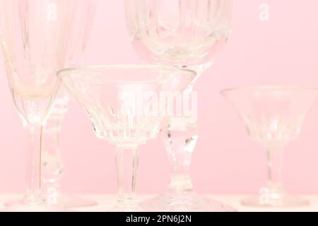 Primo piano di vetri di cristallo vintage di fronte a sfondo rosa. Foto Stock