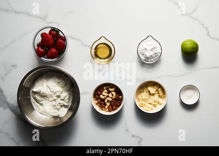 Sane barrette di yogurt greco congelato con fragola con scorza di lime, noci e cioccolato bianco lista degli ingredienti. Dolce fatto in casa Foto Stock