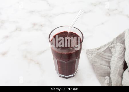 Colazione sana, frullato di mirtilli surgelati, avocado e banana, proteina di piselli e semi di lino, lattuga e sedano, mela, frullato in un bicchiere Foto Stock