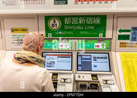 Aprile 2023, modello donna occidentale rilasciato in Giappone, acquistando un biglietto del treno della metropolitana sulla linea ferroviaria di Shinjuku, Giappone, Asia Foto Stock