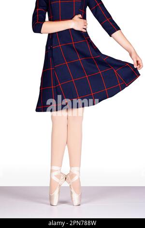 En Pointe TACCHI CORRETTI insieme mano sulla vita e tenendo blu tartan vestire la prospettiva insegnante giovane ballerina femminile in piedi classici balletto Foto Stock