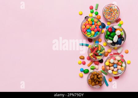 caramelle tonde di colore diverso in ciotola e vasetti. Vista dall'alto di una grande varietà di dolci e caramelle con spazio copia. Foto Stock