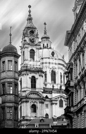 Foto verticale in bianco e nero della storica chiesa di San Nicola nel centro storico di Praga. Bella architettura religiosa medievale. Mala Foto Stock