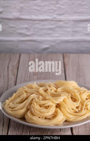 fotografare gli spaghetti in un piatto sul tavolo Foto Stock