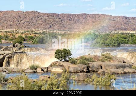 Un arcobaleno presso la cascata di Augrabies nel fiume Orange allagato. Foto Stock