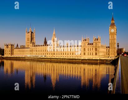 Le case del Parlamento sorgono all'alba, il Westminster Bridge, il Tamigi, Londra illuminata dall'alba limpida e dal cielo azzurro, che si riflette nel fiume Tamigi durante l'alta marea dal Westminster Bridge Londra, Regno Unito. Vista classica e senza tempo su un'alba limpida e perfetta Foto Stock