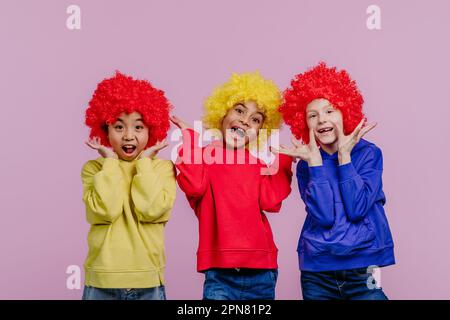 Bambini felici che giocano sui clown, spara in studio. Foto Stock